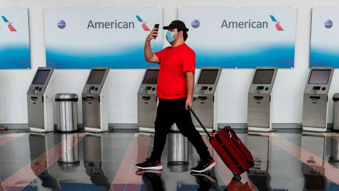 A passenger walks past empty American Airlines check-in terminals at Ronald Reagan Washington National Airport in Arlington, Virginia