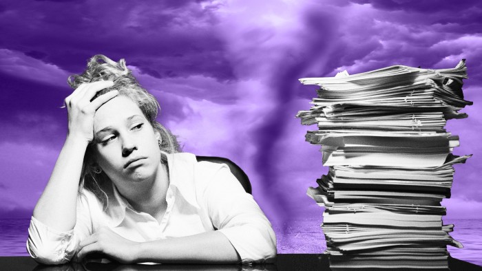 A woman staring at a pile of paperwork