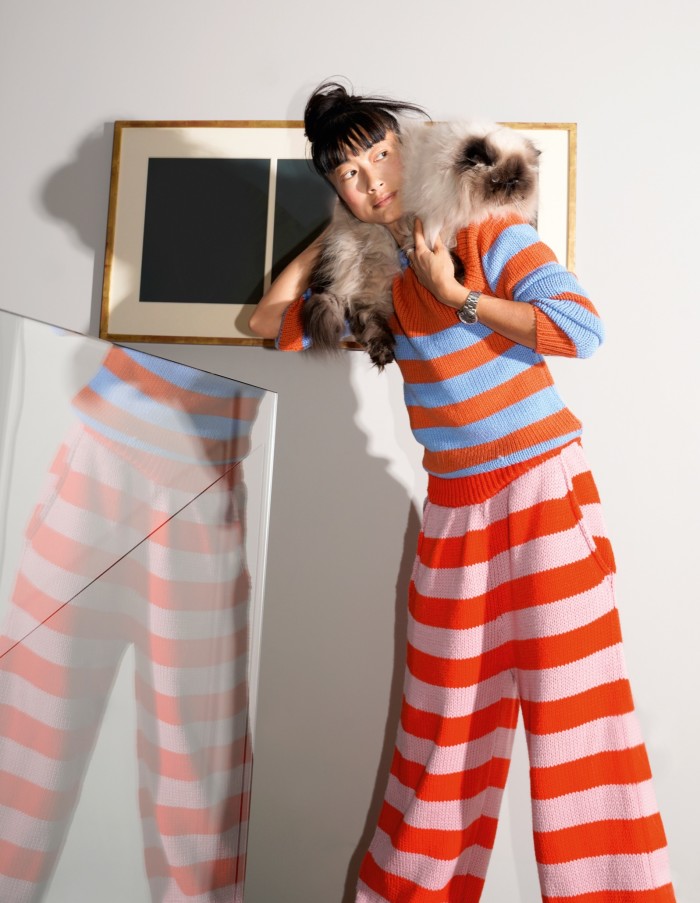 Mimi Xu at home in London with her cat, Miles. Sweater and trousers by Marni