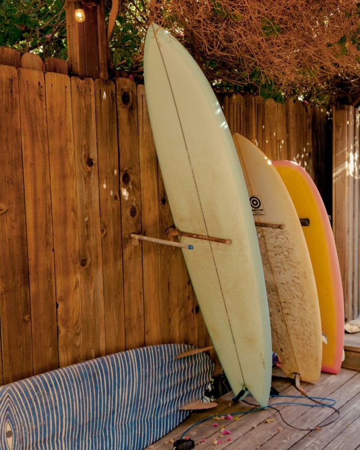 His surfboards include (far left) one with his grandmother’s artwork and (far right) his Deepest Reaches board