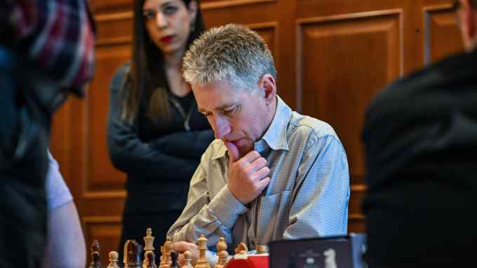 A grandmaster chess player concentrates on his next move on the board