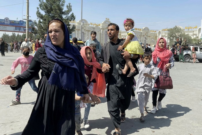 An Afghan family rushes to the international airport as they flee Kabul last week