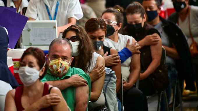 People wait after receiving doses of the Pfizer-BioNTech vaccine against COVID-19 at a vaccination center for people over 50 years old set up at the Vasconcelos Library, in Mexico City