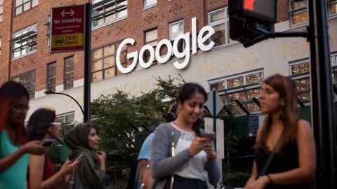 Pedestrians walk past the Google offices in New York