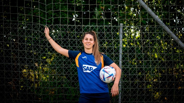 Isabella Hartig, arms crossed, stands in  front of a football goal