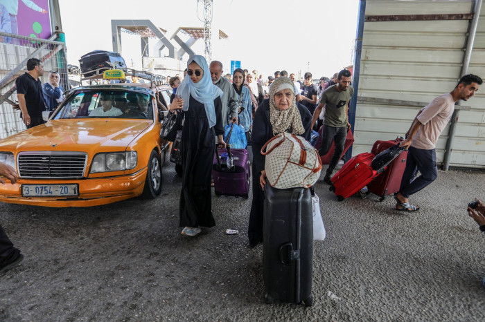 Palestinians with foreign passports at Rafah Border Gate wait to cross into Egypt