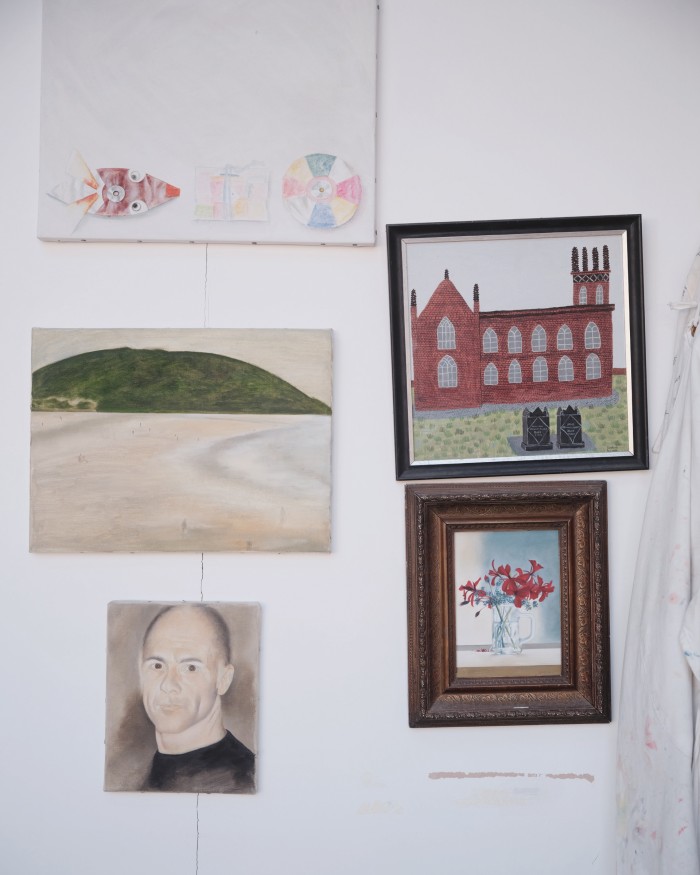 A selection of paintings mostly by Chrissy Blake, hanging in their shared home studio. The churchyard picture is by Carrie Boyd Harte