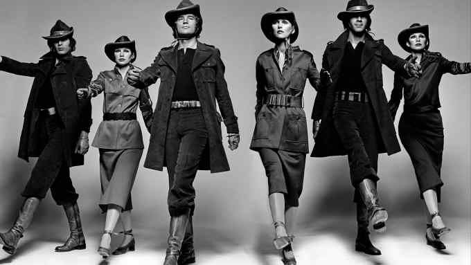 Male and female models wearing cowboy-style hats, safari suits or trousers tucked in boots march towards the camera