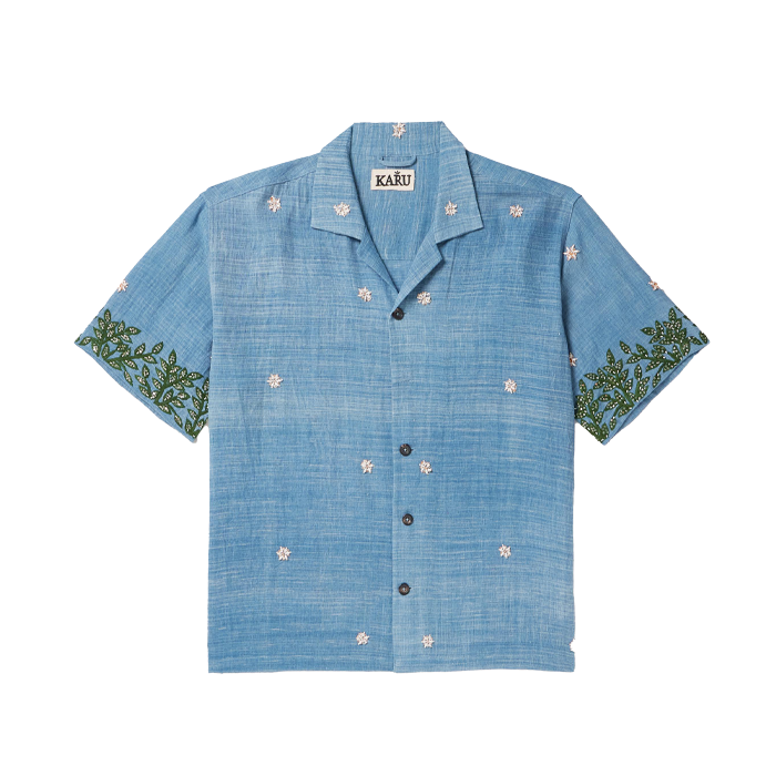 A short sleeve blue shirt with embroidered leaf pattern on the sleeves and small embroidered flowers on the shirt front