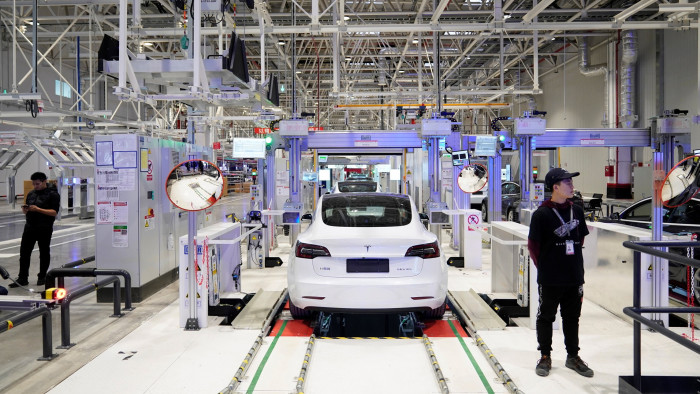 A white Tesla vehicle being manufactured inside the company’s Shanghai factory