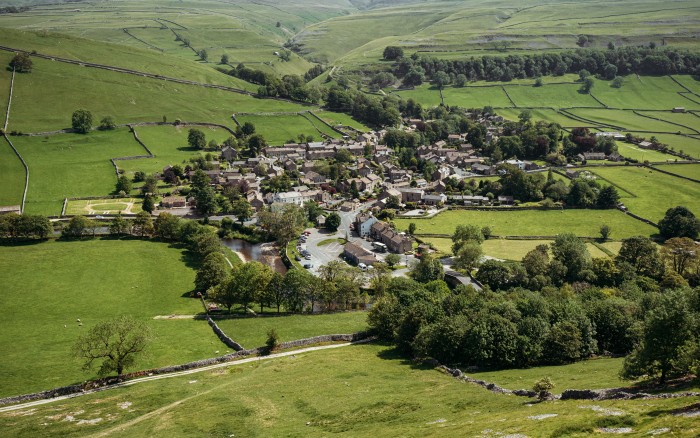 An aerial view of the Yorkshire village of Kettlewell, surrounded by green fields