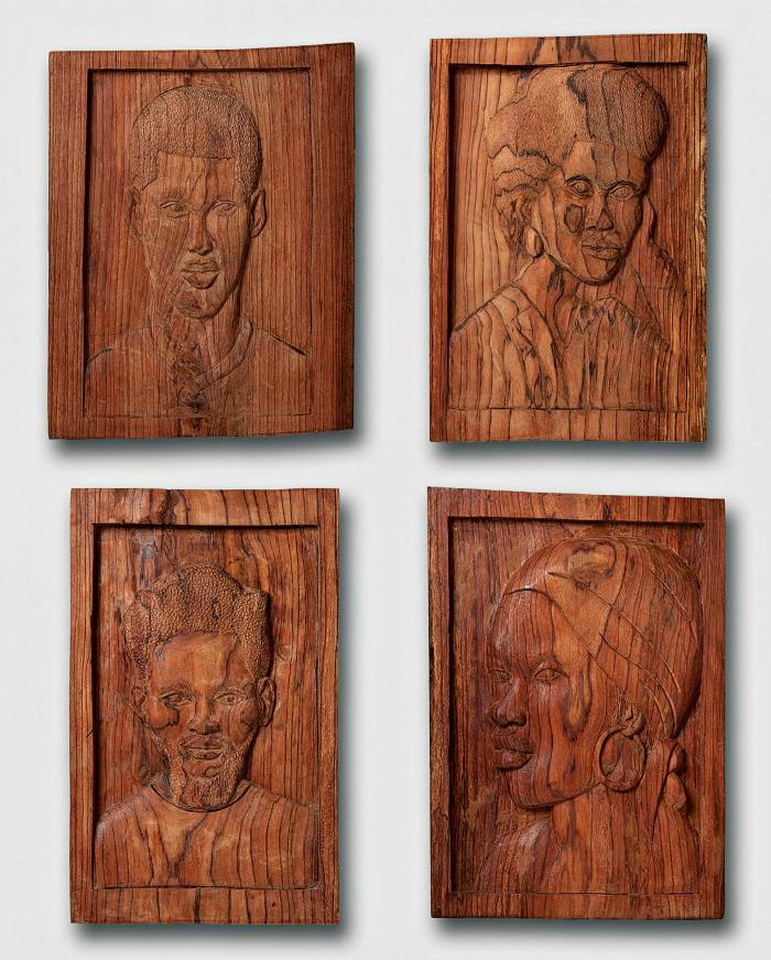 Four wooden panels carved with people’s faces