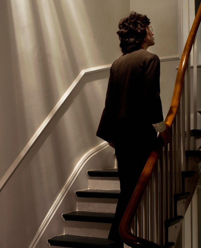 A woman wearing glasses going up a flight of stairs