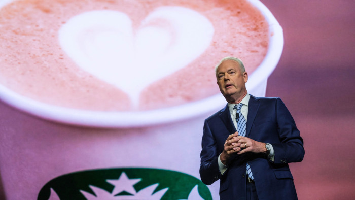Kevin Johnson, Starbucks’s former chief executive, on stage delivering a speech