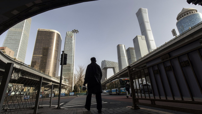 A pedestrian passes buildings in Beijing, China
