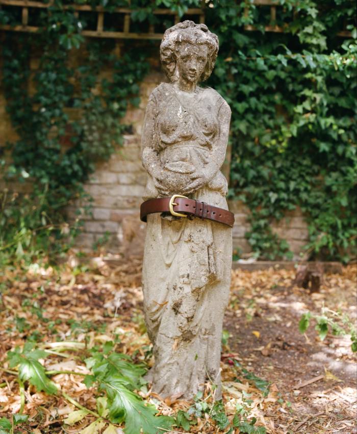 Sam’s handmade leather belt by Jasper Highet, slung on a garden statue