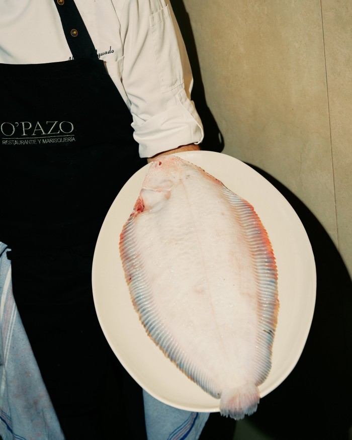 O’Pazo’s head chef Alberto Aguado holding a plate of sole