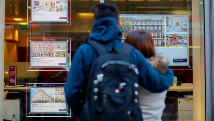 A couple look at look at an estate agent’s window in central London