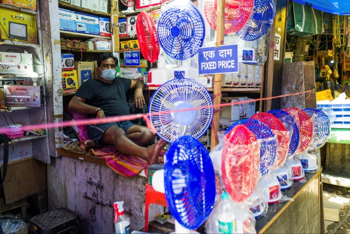A man waits for customers displaying fans at his store amid rising temperatures in New Delhi on May 27, 2020