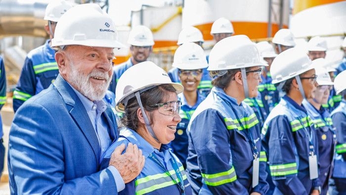 Brazil’s President Luiz Inácio Lula da Silva (leftmost) stands among workers of an industrial facility