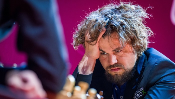 Chess player Magnus Carlsen in deep thought looking for his next move on the board