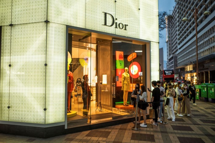 Customers queue to enter a Christian Dior store in Hong Kong