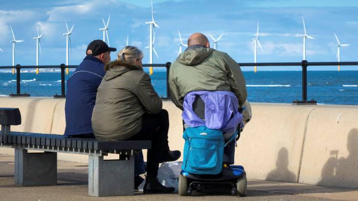 People sit on a bench on the Redcar Promenade
