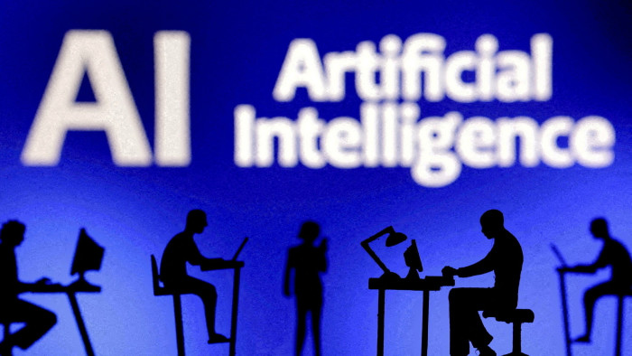 Image of people working on computers below a sign for artificial intelligence