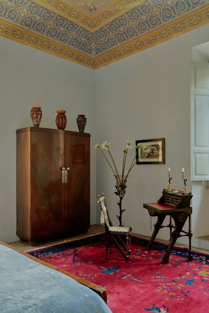A Majorelle closet and vases in the master bedroom. 18th-century candle holders sit on a table by Carlo Bugatti. A drawing by Canevari’s grandfather hangs on the wall