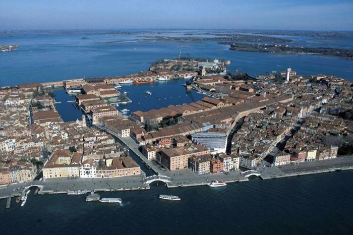Aerial view of an island filled with low buildings and a large dock 