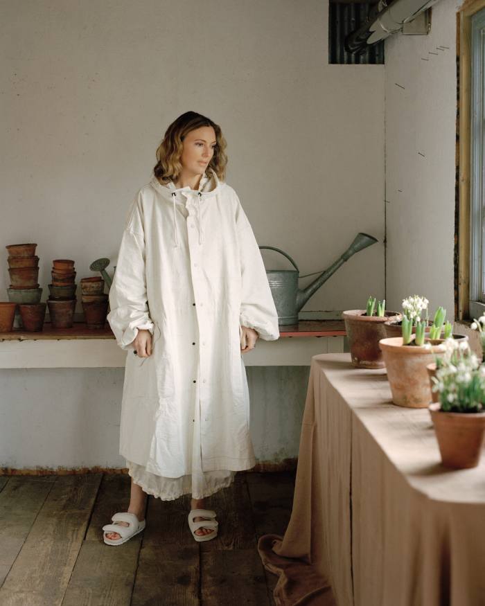 Faye Toogood in her potting shed in Hampshire, wearing the Toogood x Birkenstock canvas Forager coat, £940, cotton Forager dress, £770, and nappa leather Beachcomber sandals, £400