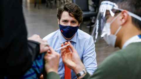 Vaccinated: Justin Trudeau observes a patient receiving a Covid jab — Blair Gable/Reuters