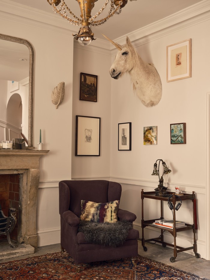 The entrance hall, with armchair upholstered in aubergine linen, Retrouvius rug and unicorn from Ed Butcher antiques