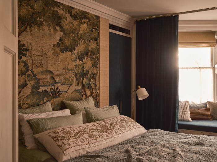 The master bedroom with Verdure tapestry headboard from Retrouvius, with raw-silk headboard surround, and hand-dyed velvet curtain and bolster by James’ long-term collaborator Kirsten Hecktermann