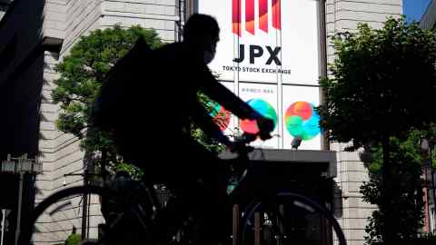 A cyclist rides past the Tokyo Stock Exchange building