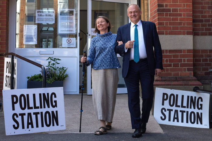 Leader of the Liberal Democrats Sir Ed Davey and his wife Emily Gasson leave the polling station after voting in Surbiton