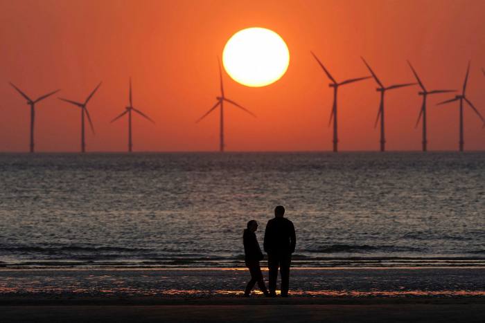 sunset over the sea and wind turbines