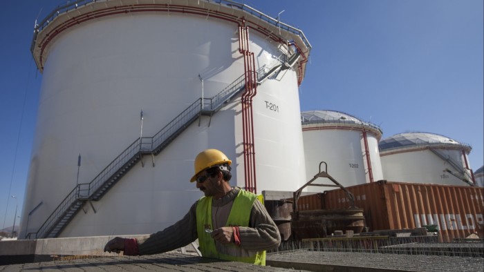 Worker outside a Vitol oil storage tanks