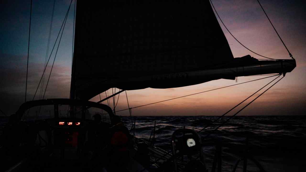 On the deck of a sailing boat at sea at night