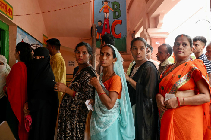 Voters queue to cast their ballots at a polling station in Varanasi on June 1, 2024, during the seventh and final phase of voting in India’s general election