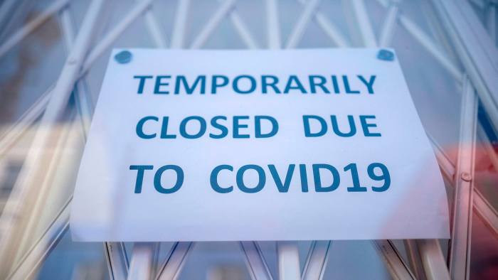 A sign on a door that says “temporarily closed due to Covid-19”