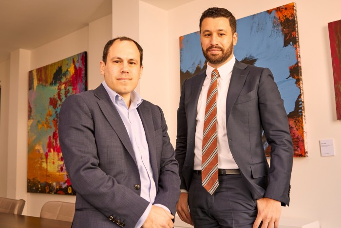 Zvi and Raphael Noé in suits photographed in an office