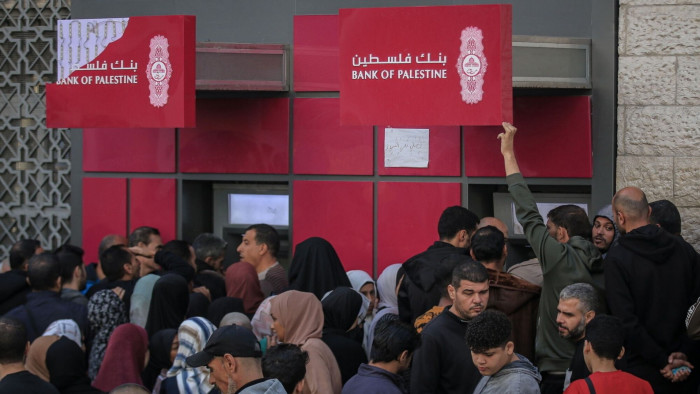 People outside a Bank of Palestine branch