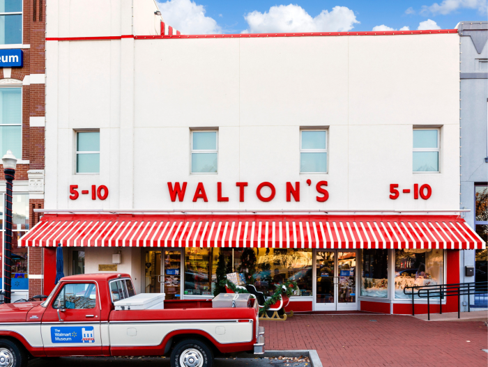 The facade of a Sam Walton’s store. A pickup truck is parked in front