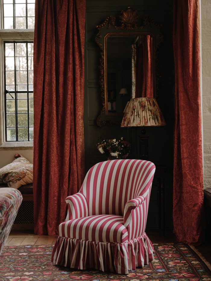 A Victorian tub chair, upholstered in Flora Soames Plain Stripe fabric, £3,850, and, behind, a 20th-century silk lampshade, £2,025