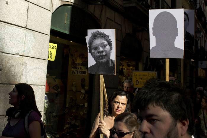 A woman holds a picture of Samba Martine of Democratic Republic of Congo who died at Madrid’s detention centre