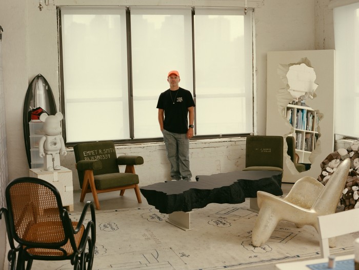 Arsham in his studio. On the left is the Snarkitecture x Bearbrick with the Haydenshapes x Arsham collaboration surfboard behind. The Wendell Castle Triad chair is on the right