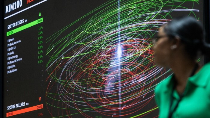 Woman looking up at computer screen showing Aim100 ‘sector risers’ data, alongside patterns of red and green spirals