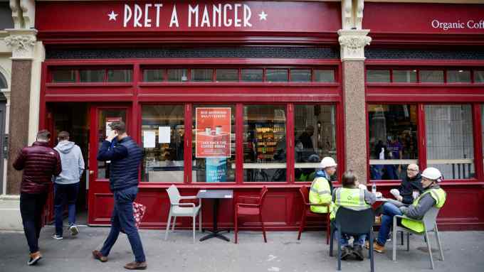 Customers queue outside a Pret A Manager sandwich shop in London