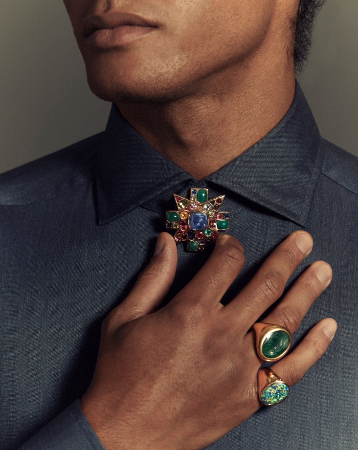Man wearing rings and a brooch
